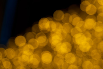 Defocused of blurred golden bokeh circle light from lighting bulb Merry Christmas and Happy New Year decorative in the night for abstract background texture