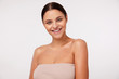© timtimphoto - Indoor shot of cheerful young pretty brunette woman with natural makeup looking at camera with charming smile while standing against white background, being in nice mood