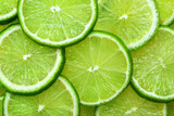 Close-up juicy Lime slices abstract background in pastel green color. Bright summer texture.