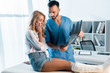 handsome orthopedist and shocked woman looking at x-ray