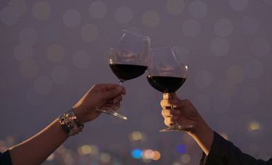 Wall Mural - Romantic couple or friendship which happy moment relaxing ,red,wineglass,celebration on the rooftop in the night with bokeh background