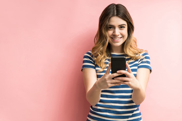 Wall Mural - Happy Young Female With Mobile Phone In Studio