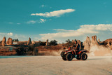 Fototapeta Koty - Young woman in safari trip through desert driving Quad ATV. Cappadocia Turkey