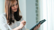 © themorningglory - Business asian women use tablet computer sitting in cozy curtain room