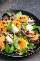 Wall Mural - Detox salad with tangerines, mozzarella, herbs, pomegranate seeds and nuts on a dark background.