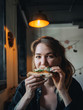 © paulzhuk - Girl woman eats pizza in cosy cafe