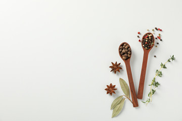 Wall Mural - Wooden spoons with pepper spices and ingredients on white background, top view