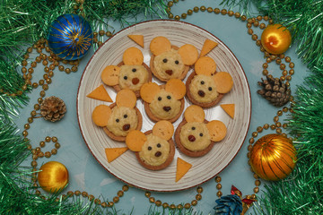 Tartlets Mice with cheese fo the New Year 2020 on a plate on light blue background, horizontal orientation