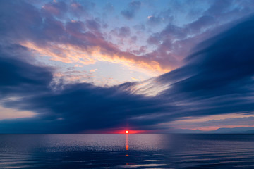 Wall Mural - Beautiful sunset in blue clouds on the seashore