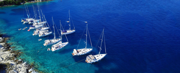 Aerial drone ultra wide photo of sail boats docked in paradise bay of Fiskardo, Kefalonia island, Ionian, Greece