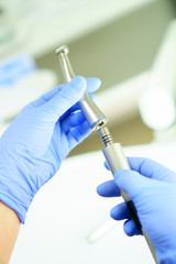 A medical worker connects a disassembled boron machine for dental treatment, preparation for treatment, repair of a medical instrument, breakdown of a medical instrument