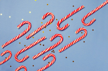 Merry Christmas candy can in row on blue background. Flat lay