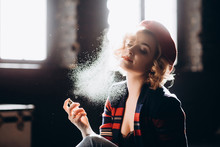 A Beautiful Blonde Woman In A Red Beret Holds A Small Bottle In Her Hands Spraying Perfume On Herself Enjoys Armature. Backlight, Soft Focus.