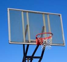 A Close View Of The Glass Backboard Basketball Hoop.