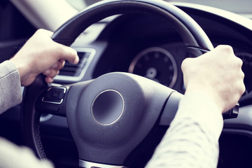 Man holding steering wheel and driving his car