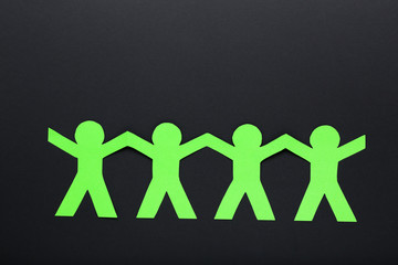 Wall Mural - Paper chain people on black background