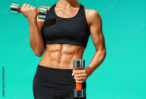 Cuadros en Lienzo Close up of sporty young woman with muscular body on grey background with copy space