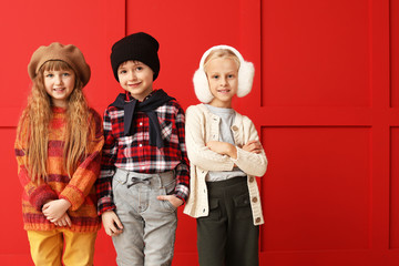 Poster - Cute little children in autumn clothes near color wall