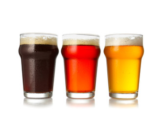 Glasses of fresh beer on white background