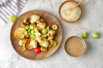 Bowl of tasty tahini and grilled vegetables on table