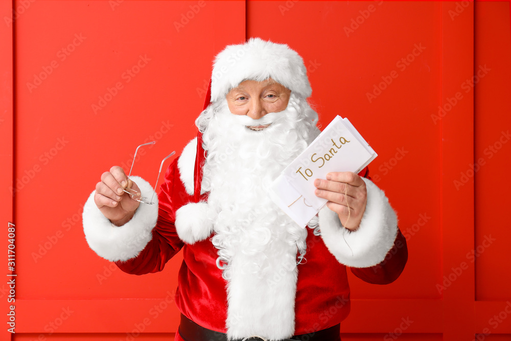 Santa Claus with letters on color background