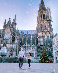 Cologne Germany , young couple on a city trip in December during snow visit the huge Cathedral of Cologne Koln Dom