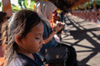 © ellinnur - semporna, Malaysia - Nov 27, 2019: Young girl looking tired while sitting on a walkaway in a sunny day.
