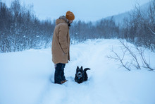 The Man Walks With His Dog In A Winter Forest