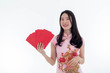© K-MookPan - Chinese new year with Beauty smiling woman wears dresses traditional cheongsam holds a red pocket, studio shot isolated on white background.