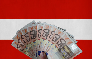 Austria flag with Euro banknotes in the hand