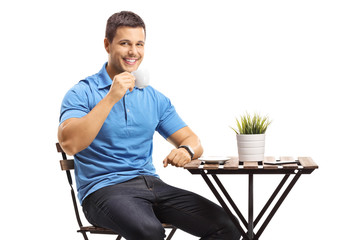 Sticker - Young man drinking coffee at a table