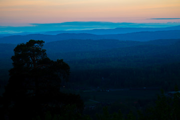 sunset behind layers of blue hills