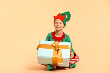 Sticker - Little boy in costume of elf and with gift on color background