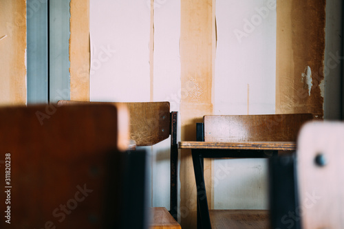 selective soft and blur focus.old wooden row lecture chairs in dirty classroom in poor school.study room without student.concept for education in third world ,donate and charity,background text