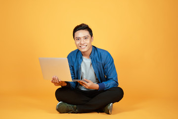 Sticker - portrait of handsome asian man smiling while using computer laptop. success or achievement concept