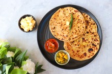 Indian Food - Aloo Paratha Or Indian Potato Stuffed Flatbread. Served With Butter For Breakfast, Pickle And Masala Potatoes Among With Indian Tea Or Masala Chai.  With Copy Space.