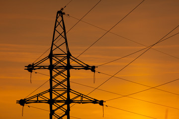 Electric pole with wires on a sunset background