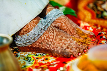 Indian bridal putting anklets in leg 