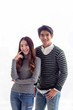 © Jaowfah - Portrait Asian male and female lovers wear long-sleeve sweaters, smiling happily for the camera on a white background.