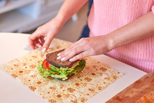Woman Hands Wrapping A Healthy Sandwich In Beeswax Food Wrap
