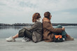 © Romvy - Portrait of Two Fashion Girls, Best Friends Outdoors, Wearing Stylish Jacket, Walking Near the Lake