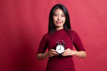 Wall Mural - Young Asian woman smile with a clock.