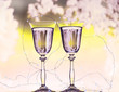 Two glasses with sparkling champagne wine and a garland with lights on the background of frosty patterns .The winter mood of winter