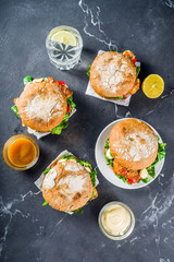 Various seafood and fish burgers assortment. Homemade healthy burger with grilled prawn, salmon, tuna, sea bass, fresh herbs, mozzarella cheese and baby spinach.