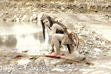 A Young Woman Is  Dressed As A Neanderthal Warrior.  She Is Covered With Mud, Filth And Dirt And Is Seen In  A Stone Quarry Area Surrounding.