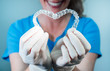Female doctor holding two transparent heart-shaped dental aligners