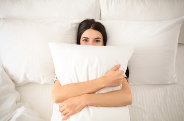 Sticker - Young woman with pillow in bed, top view. Lazy morning