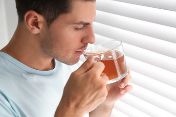 Poster - Man with cup of tea near window. Lazy morning