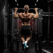© daniil - power muscular bodybuilder guy doing pullups in gym. Fitness man pumping up lats muscles. Fitness and bodybuilding training health lifestyle concept