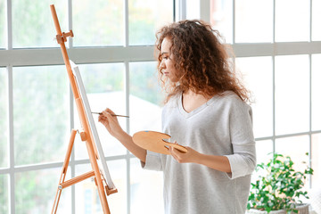 Wall Mural - Beautiful female African-American artist painting in studio